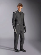 Macacão Alpinestars GP Tech V4, macacão de automobilismo de uma peça, preto e branco, usado com luvas e calçado de competição a combinar, com logótipos brancos nos ombros e antebraços, design profissional e elegante para desportos motorizados