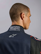 Macacão Alpinestars GP Tech V4 em Azul Marinho, Preto e Vermelho, grande plano da gola traseira com a etiqueta de certificação FIA 8856-2018 e logótipo da Alpinestars bordado a branco, detalhe de macacão de automobilismo de alta performance