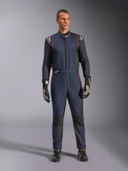 Macacão Alpinestars GP Tech V4, macacão de automobilismo profissional em azul marinho e preto com detalhes em vermelho, equipamento de corrida de peça única com certificação FIA, usado com luvas e calçado de corrida pretos, vestuário para piloto de desportos motorizados