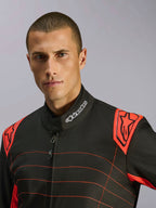 Grande plano de um piloto a usar o Macacão Alpinestars KMX-9 V3 em Preto e Vermelho Fluo, com um logótipo bordado no colarinho e dragonas vermelhas nos ombros com a marca Alpinestars, design de equipamento técnico de karting
