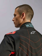 Fato Alpinestars KMX-9 V3, fato de karting preto e vermelho fluorescente, vista aproximada da parte superior das costas e da gola num modelo, com o logótipo Alpinestars branco, costuras vermelhas detalhadas e etiqueta de certificação FIA no pescoço