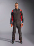 Fato de Karting Alpinestars KMX-9 V3, preto e vermelho fluo, fato de corrida de peça única usado com luvas e botas coordenadas, com pormenores vibrantes nos ombros e costuras a vermelho, logótipo Alpinestars na parte inferior das pernas, design elegante de desporto motorizado para corridas em pista