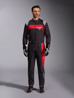 Alpinestars KMX-9 V3 Graphic 3 Suit, fato de karting, preto e vermelho, vista frontal de corpo inteiro usado por um modelo, com painéis gráficos vermelhos arrojados e logótipos brancos, combinado com luvas e sapatilhas de corrida pretas, vestuário profissional de desportos motorizados.