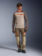 Alpinestars Maxdura Dual Jersey in Aluminum Walnut, adventure motorcycle jersey with tan mesh torso and brown sleeves, featuring red collar and horizontal chest stripe with Alpinestars logo, worn with matching adventure pants and gloves.