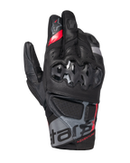 Alpinestars Belize V3 Drystar Gloves, luvas de motociclismo de aventura de punho curto, pretas com detalhes vermelhos e cinzentos, com proteção rígida nos nós dos dedos com padrão hexagonal, painéis em pele perfurada e marcação 'ADVENTURE' no punho.