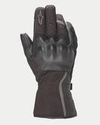 Luvas Alpinestars Stella Tourer W-7 Drystar® para Mulher, luvas de motociclismo de inverno pretas com punho longo, construção em pele e softshell, proteção rígida nos nós dos dedos coberta por pele, detalhes prateados refletores e logótipo Alpinestars no dedo.