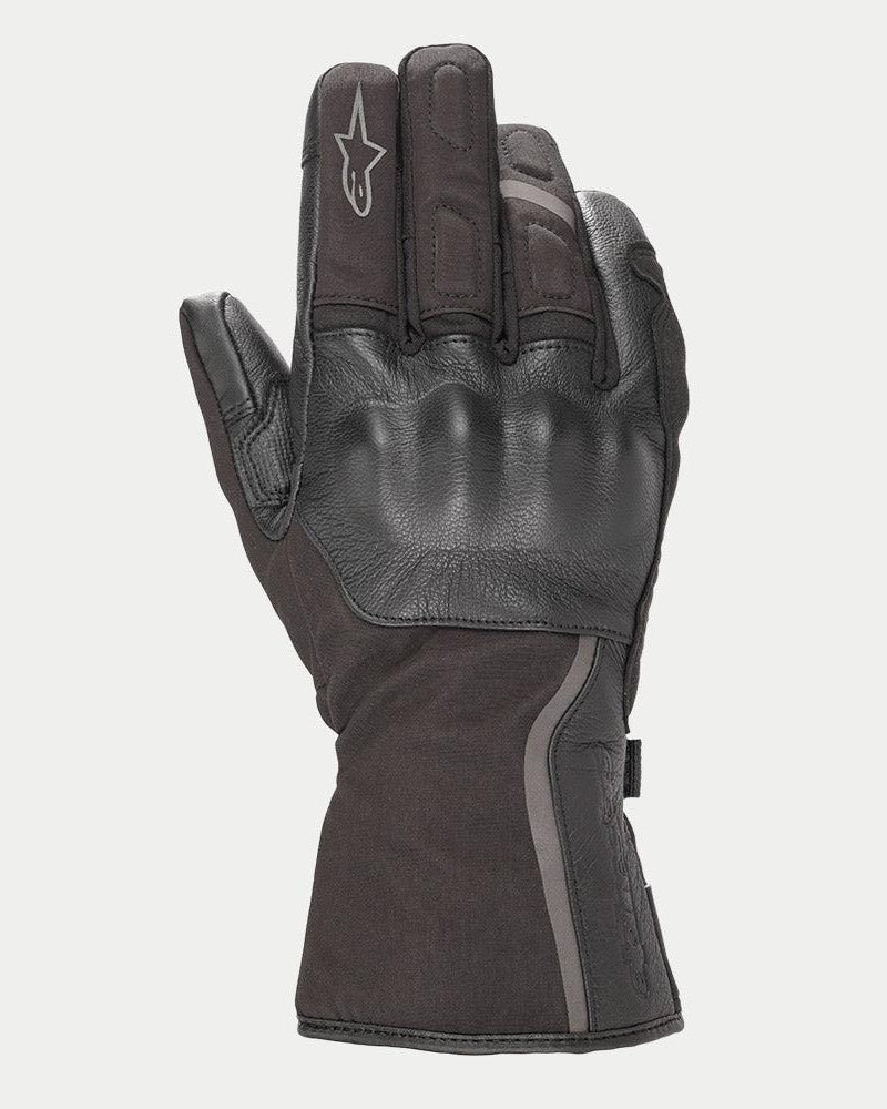 Luvas Alpinestars Stella Tourer W-7 Drystar® para Mulher, luvas de motociclismo de inverno pretas com punho longo, construção em pele e softshell, proteção rígida nos nós dos dedos coberta por pele, detalhes prateados refletores e logótipo Alpinestars no dedo.