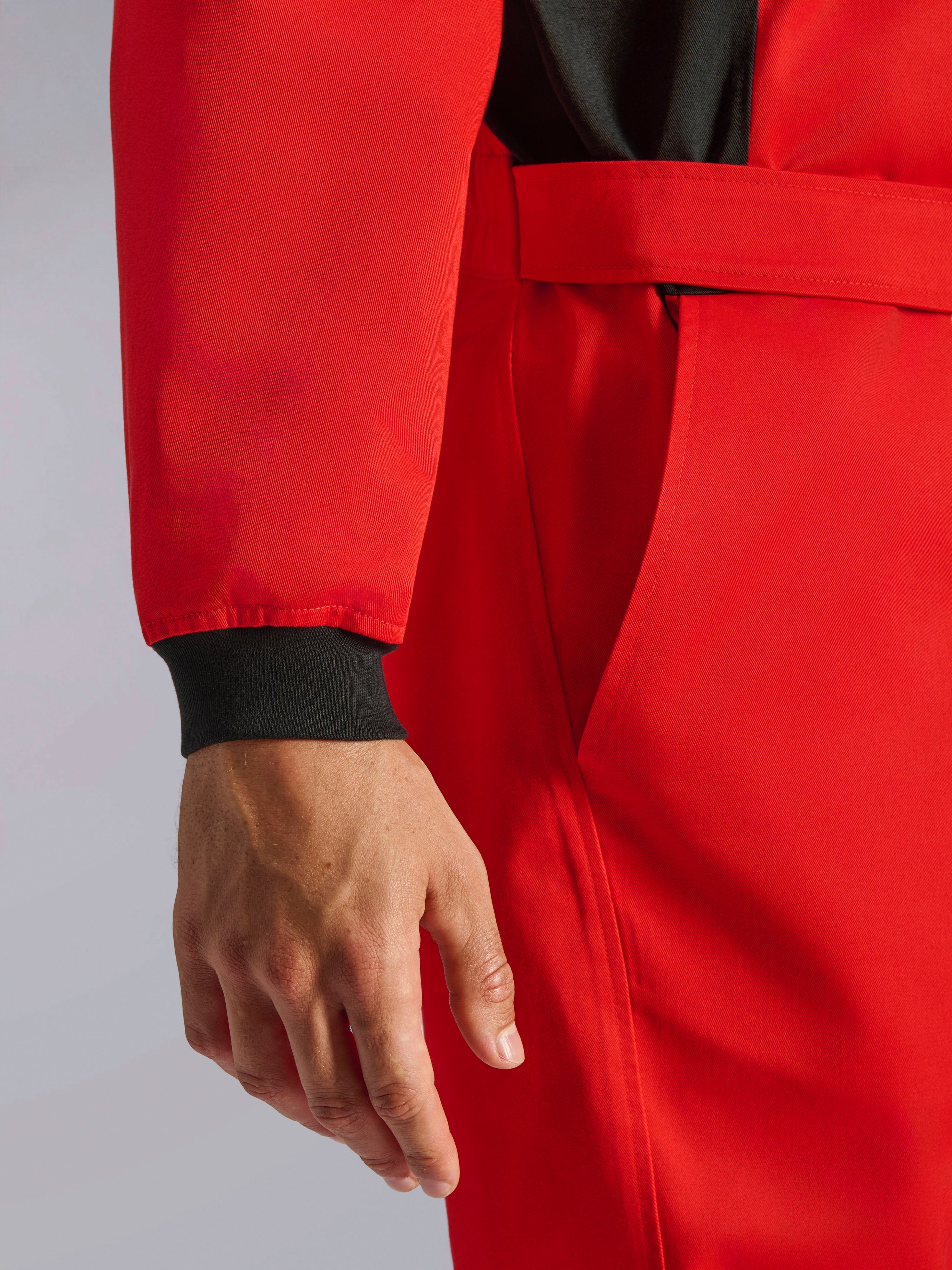 Alpinestars Kart Indoor V2 Suit, fato de karting vermelho, grande plano mostrando o punho tricotado preto, o cinto de cintura ajustável e o material de sarja durável de camada única