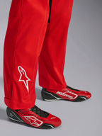 Fato Alpinestars Kart Indoor V2, vermelho, detalhe da parte inferior da perna com logótipo de estrela bordado a branco, usado com sapatos de karting vermelhos e pretos a condizer, material de sarja de poli-algodão de camada única para karting recreativo