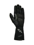 Alpinestars Tech-M V2 Gloves FIA, luvas para mecânicos de boxes, pretas e brancas, vista da palma mostrando couro texturizado e remendos de silicone aderentes, logótipo de estrela branca no punho elástico, concebidas para a utilização de pistolas de rodas em desportos motorizados