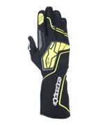 Luvas Alpinestars Tech-1 KX V4, luvas de karting, cinzento, preto e amarelo fluorescente, vista do dorso com construção em malha respirável, logótipo Alpinestars grande em amarelo, marca nominativa branca no pulso, estrela amarela no dedo indicador, design desportivo moderno