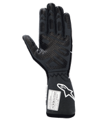 Luvas Alpinestars Tech-1 Race V4, luvas profissionais de automobilismo, preto Tar Gray, vista da palma com padrões extensos de aderência em silicone nos dedos e na palma, punho de manopla estendido com logótipo Alpinestars branco e etiquetas de certificação FIA/SFI