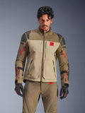 Casaco Alpinestars Nazca 3L GORE-TEX PRO, casaco de motociclismo para turismo de aventura, castanho Walnut Rock e bege com detalhes vermelhos, com reforços nos ombros em Superfabric preto e fechos vermelhos nas mangas, usado por um motociclista com equipamento a condizer, vestuário técnico de aventura premium
