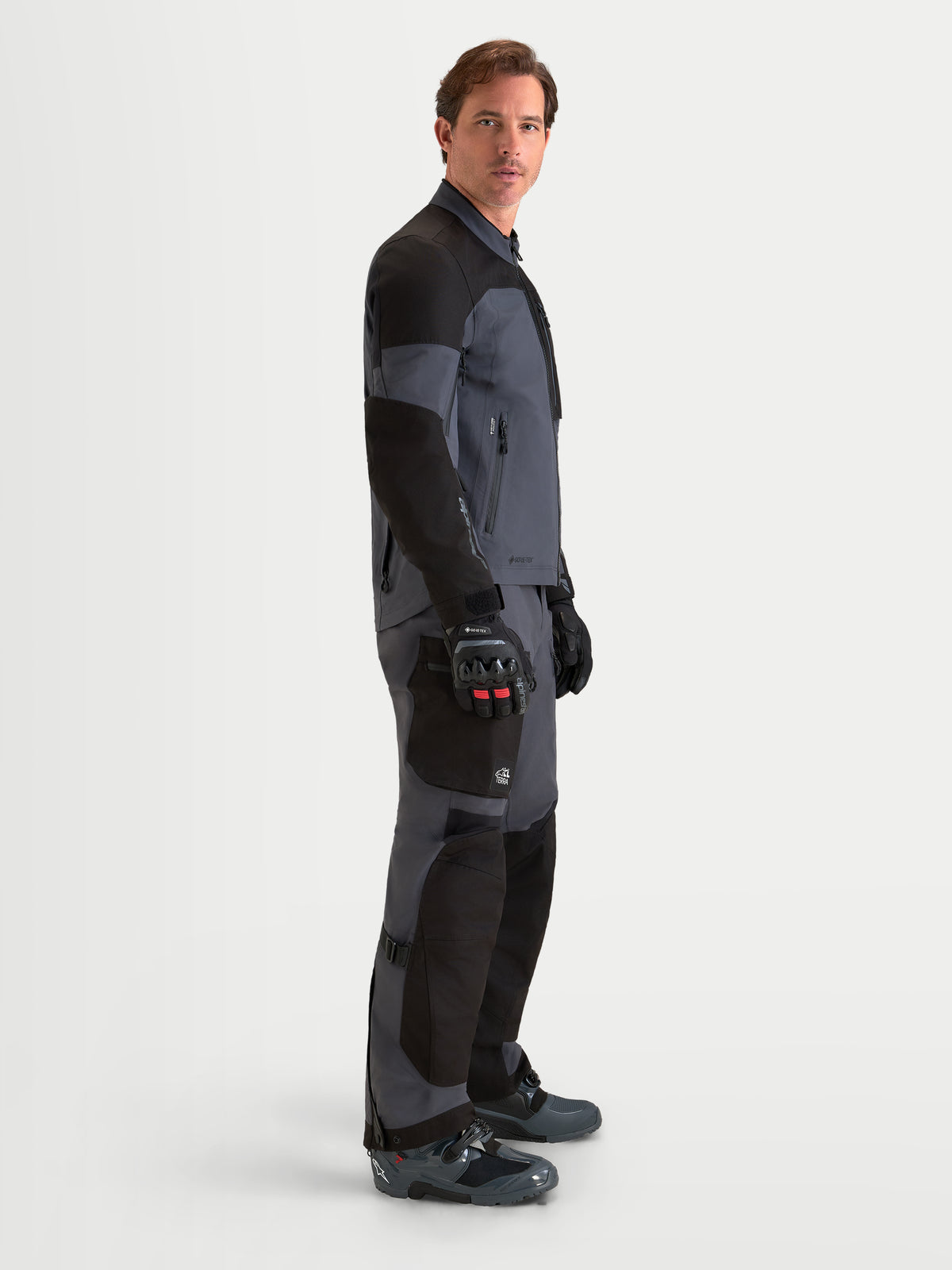 Alpinestars Arenis Gore-Tex casaco de moto adventure para homem, preto e cinzento escuro, vista de perfil lateral a mostrar a construção têxtil impermeável e a gola ergonómica num modelo