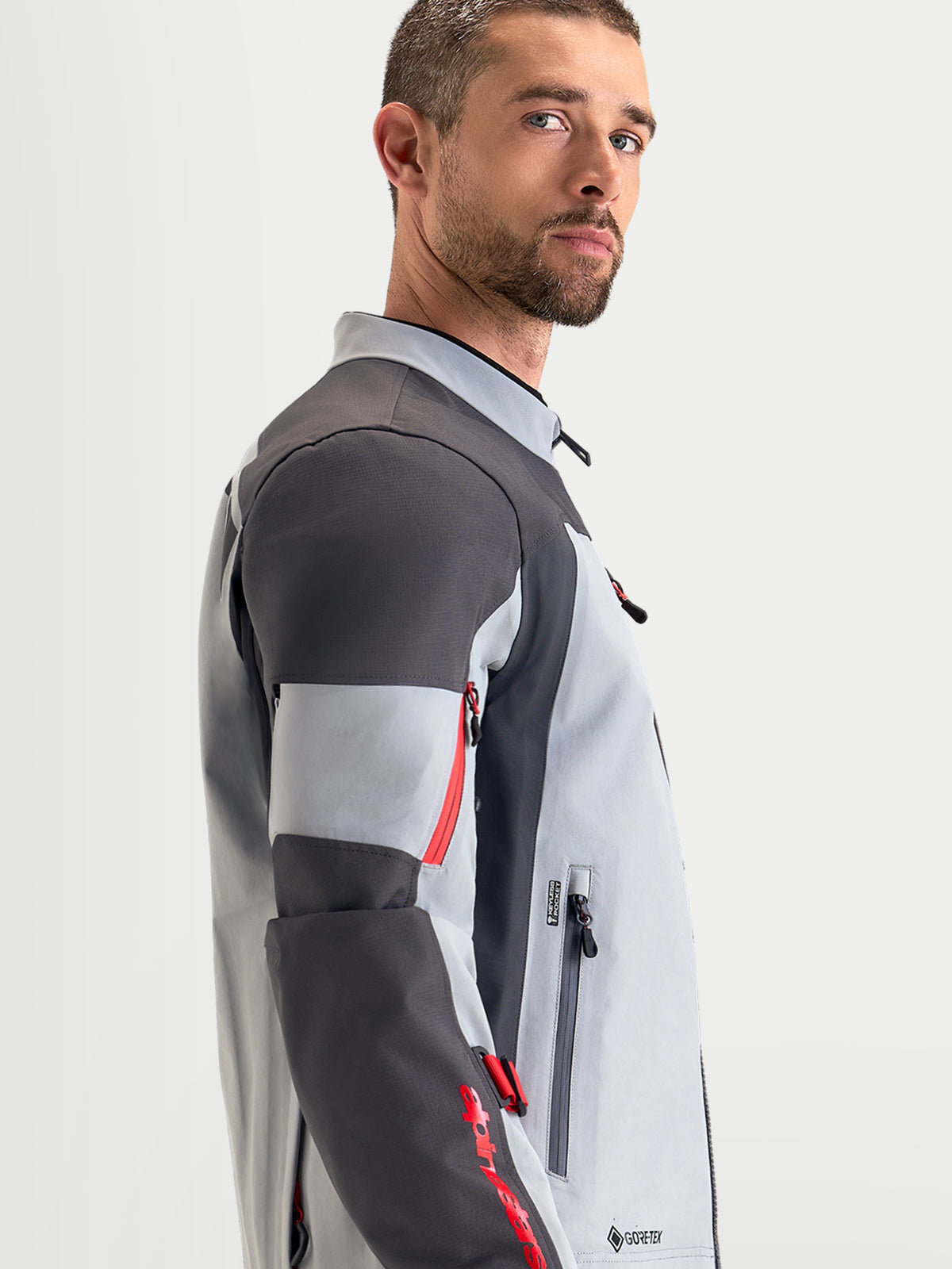 Alpinestars Arenis Gore-Tex, casaco de moto para aventura para homem em cinzento-médio, cinzento-escuro e preto, vista de perfil lateral mostrando a construção têxtil impermeável e o colarinho ergonómico
