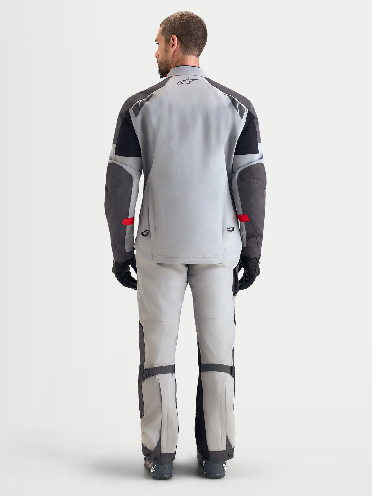 Alpinestars Arenis Gore-Tex Gear Set, casaco e calças de moto adventure para homem em cinzento claro e cinzento escuro, vista traseira num modelo a mostrar a construção em tecido GORE-TEX impermeável e o corte ergonómico