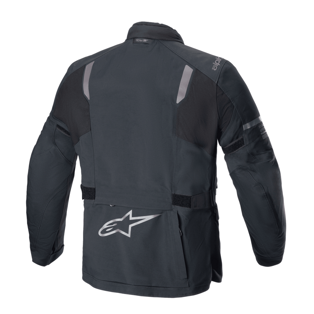 Casaco Alpinestars ST-7 2L GORE-TEX, vista traseira, preto e cinzento escuro, com painéis refletores nos ombros, logótipo da estrela Alpinestars prateado na parte inferior das costas e correias de ajuste na cintura, equipamento de motociclismo de turismo de aventura
