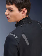 Casaco Alpinestars ST-7 2L GORE-TEX, casaco de motociclismo preto e cinzento escuro, vista em pormenor da gola com ajuste por cordão elástico e etiqueta Tech-Air, detalhes refletores cinzentos e logótipo da marca no ombro