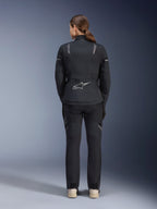 Casaco Alpinestars Stella ST-7 2L GORE-TEX Feminino, preto e cinzento escuro, vista traseira com o logótipo prateado da Alpinestars na parte inferior das costas, combinado com calças têxteis pretas a condizer, equipamento de motociclismo adventure touring