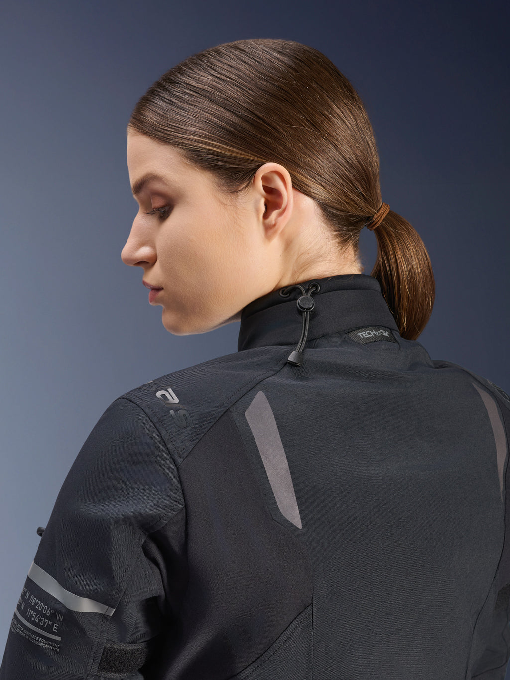 Casaco Alpinestars Stella ST-7 2L GORE-TEX para Mulher, casaco de motociclismo, preto, vista lateral-traseira mostrando o fecho de gola ajustável com cordão elástico, detalhes refletores nos ombros e marca Tech-Air Ready, design funcional para touring de aventura