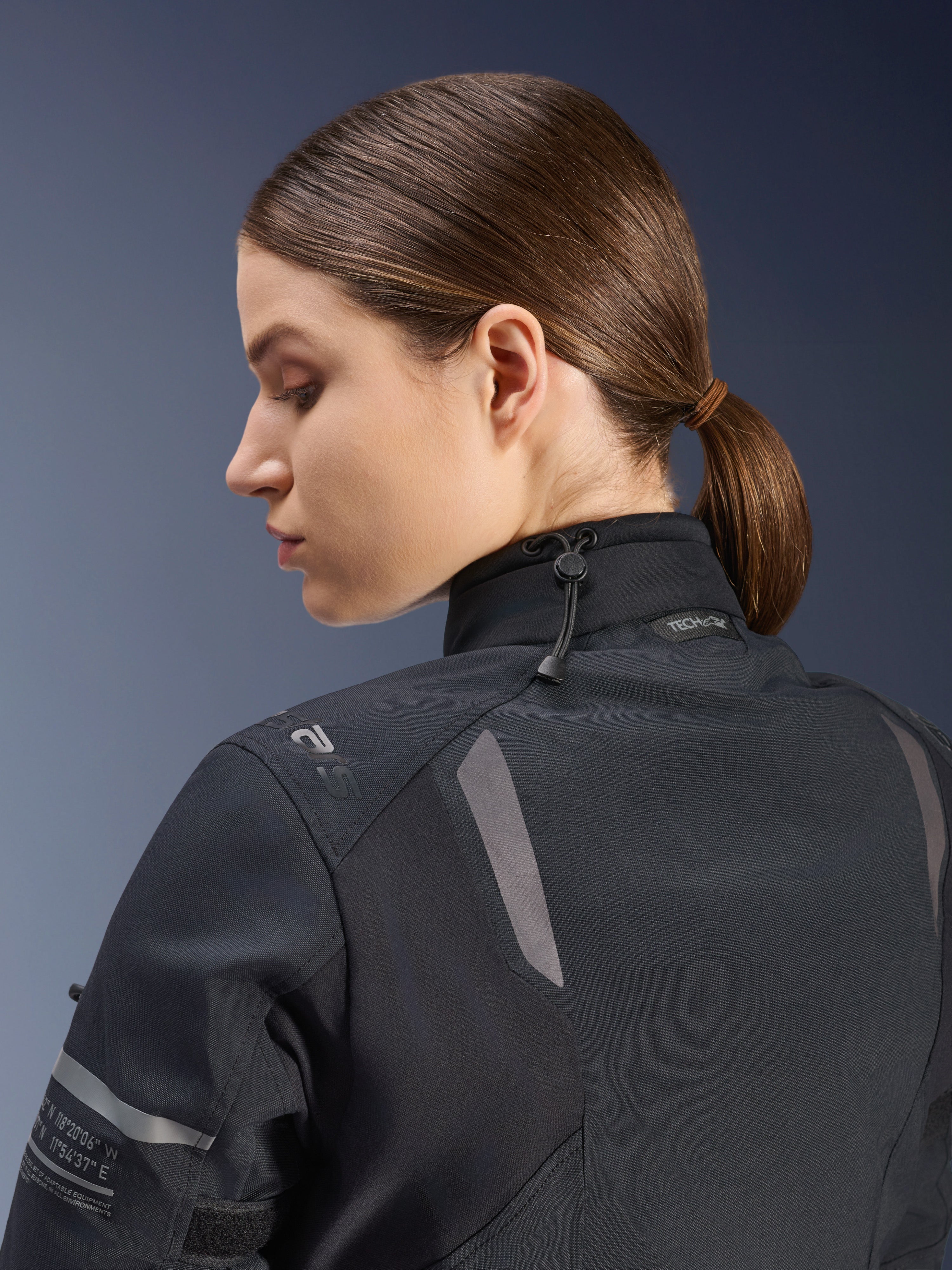 Casaco Alpinestars Stella ST-7 2L GORE-TEX para Mulher, casaco de motociclismo, preto, vista lateral-traseira mostrando o fecho de gola ajustável com cordão elástico, detalhes refletores nos ombros e marca Tech-Air Ready, design funcional para touring de aventura