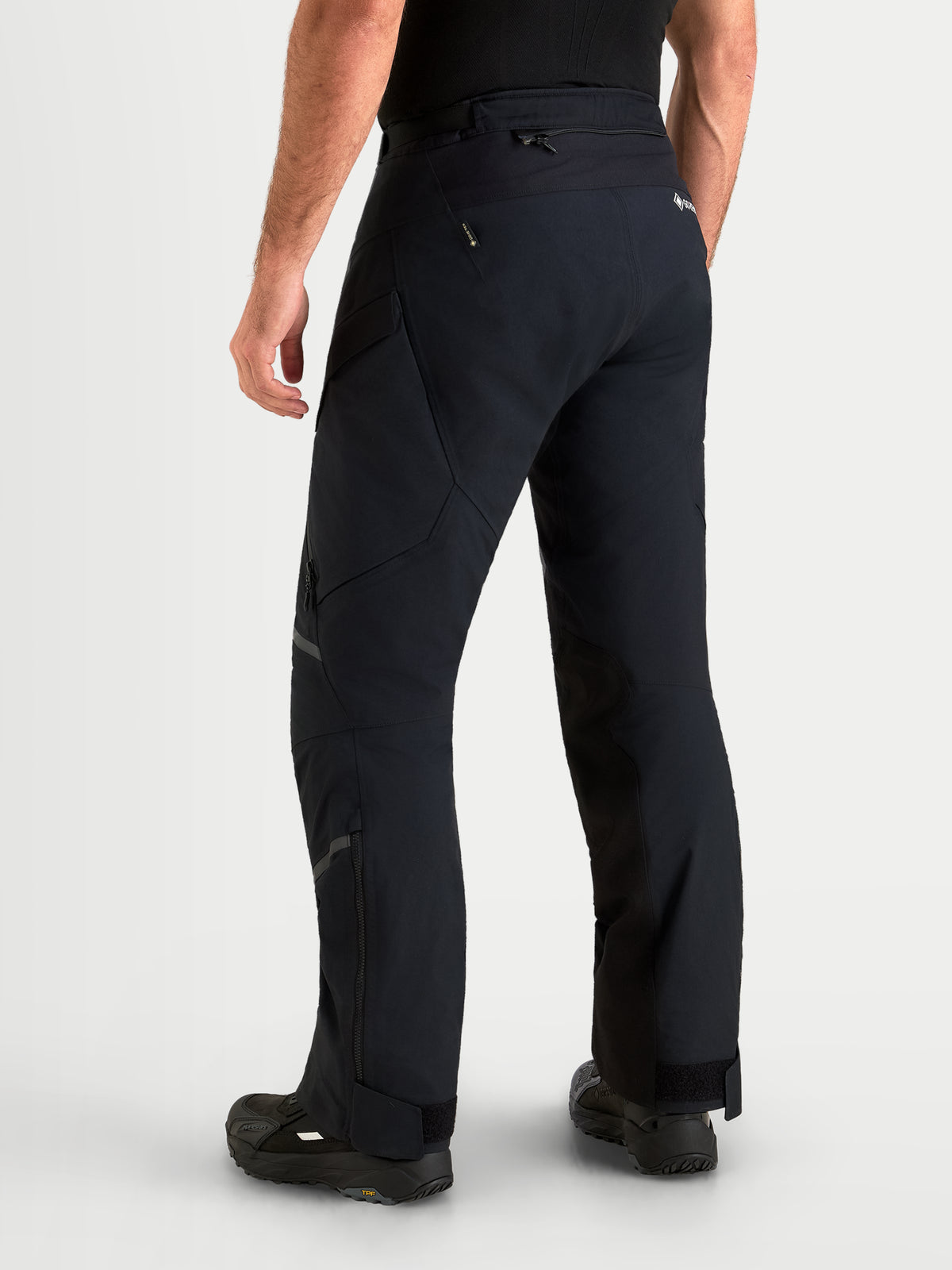 Alpinestars St-7 V2 2L Gore-Tex Pants Short, men's adventure touring motorcycle pants in black, rear profile view on a model showing waterproof textile construction and short-cut fit.