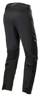 Alpinestars Road Tech GORE-TEX Pants Short, pretas, vista traseira 3/4 com fecho de correr de ligação na cintura, correias ajustáveis nos gémeos e reforços de nylon balístico, equipamento de touring de aventura impermeável