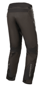 Calças Alpinestars Road Pro GORE-TEX, calças de motociclismo pretas, vista traseira que mostra o corte touring ajustado, construção em tecido técnico, logótipo Alpinestars na parte inferior da perna, painéis elásticos em acordeão e correias ajustáveis para touring de aventura.