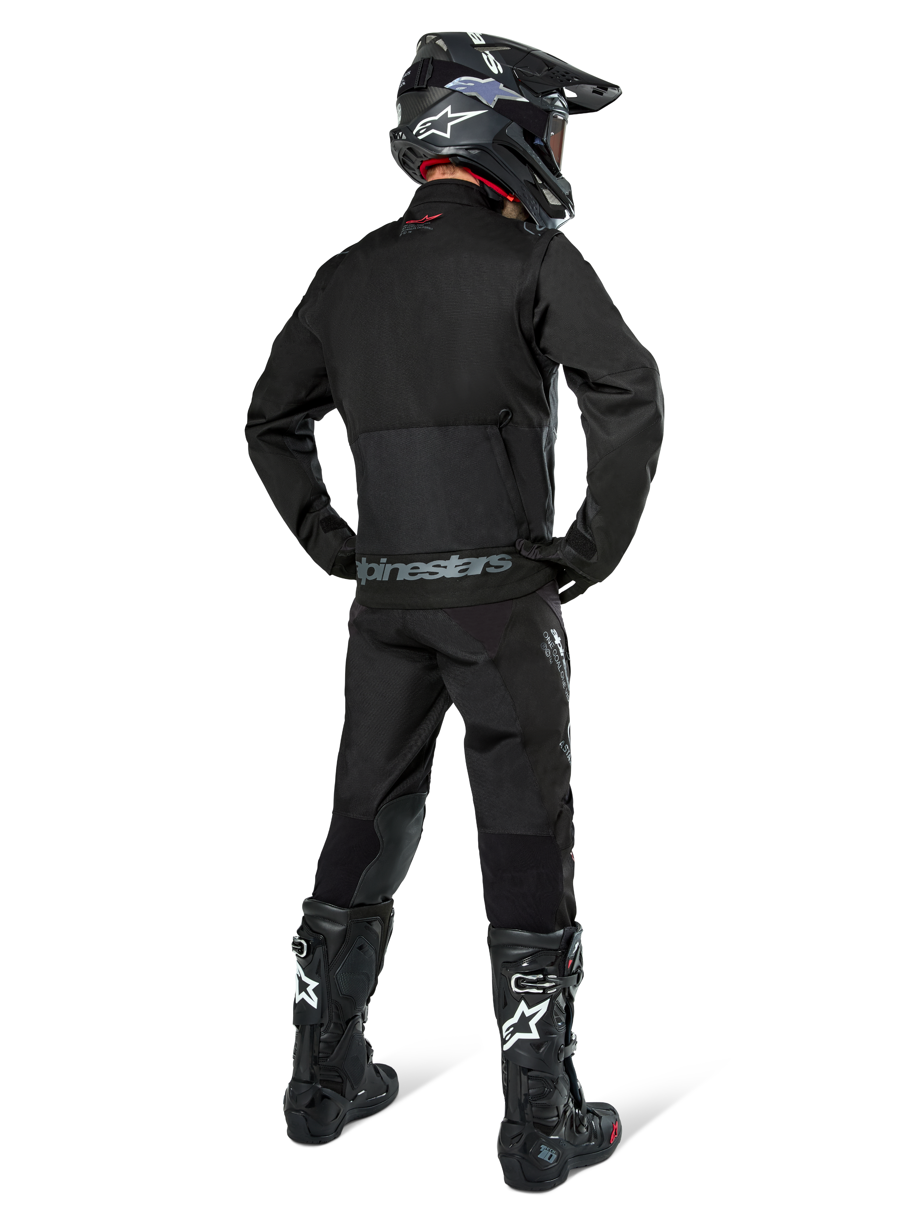 Alpinestars Pro-Dura Jacket, Black Off-road Enduro Jacket, rear view worn with matching pants and black Tech 10 boots, featuring prominent Alpinestars branding on the lower back, rugged textile construction for aggressive trail riding