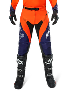 Alpinestars Pro-Dura Pants, Motocross and Enduro Pants, Navy Hot Orange and White, featuring black panels and white logos, worn with black off-road boots and gloves, professional protective gear for trail and off-road riding