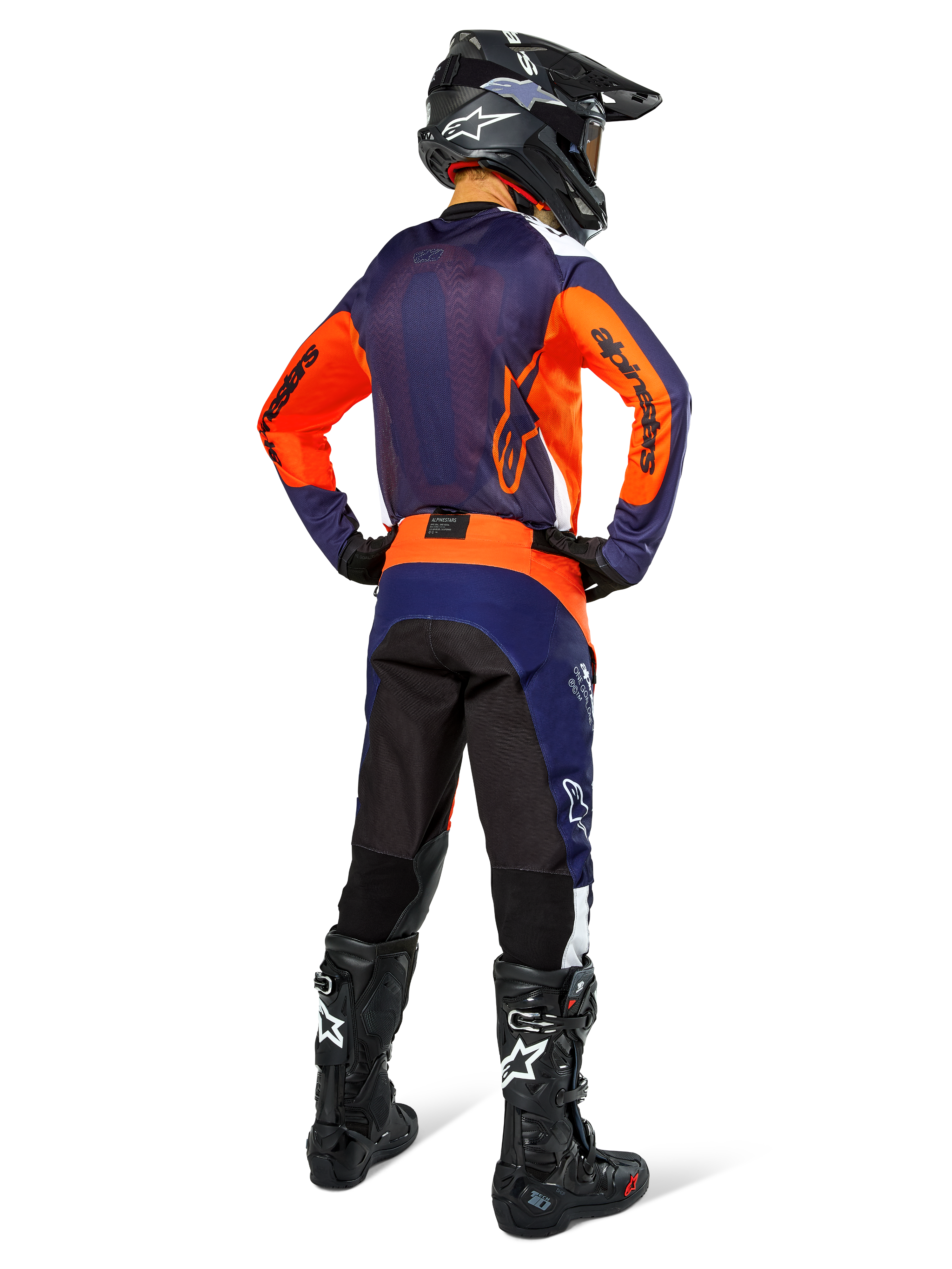 Motocross rider wearing complete racing gear from the back, Navy and orange jersey, Pro-Dura Pants in Navy Hot Orange White, black helmet and black boots, professional off-road racing outfit ensemble.