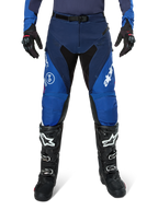 Alpinestars Pro-Dura Pants, calças de motocross, azul-marinho e azul vivo com detalhes brancos, vista frontal, usadas com botas e luvas pretas, design técnico para enduro e todo-o-terreno