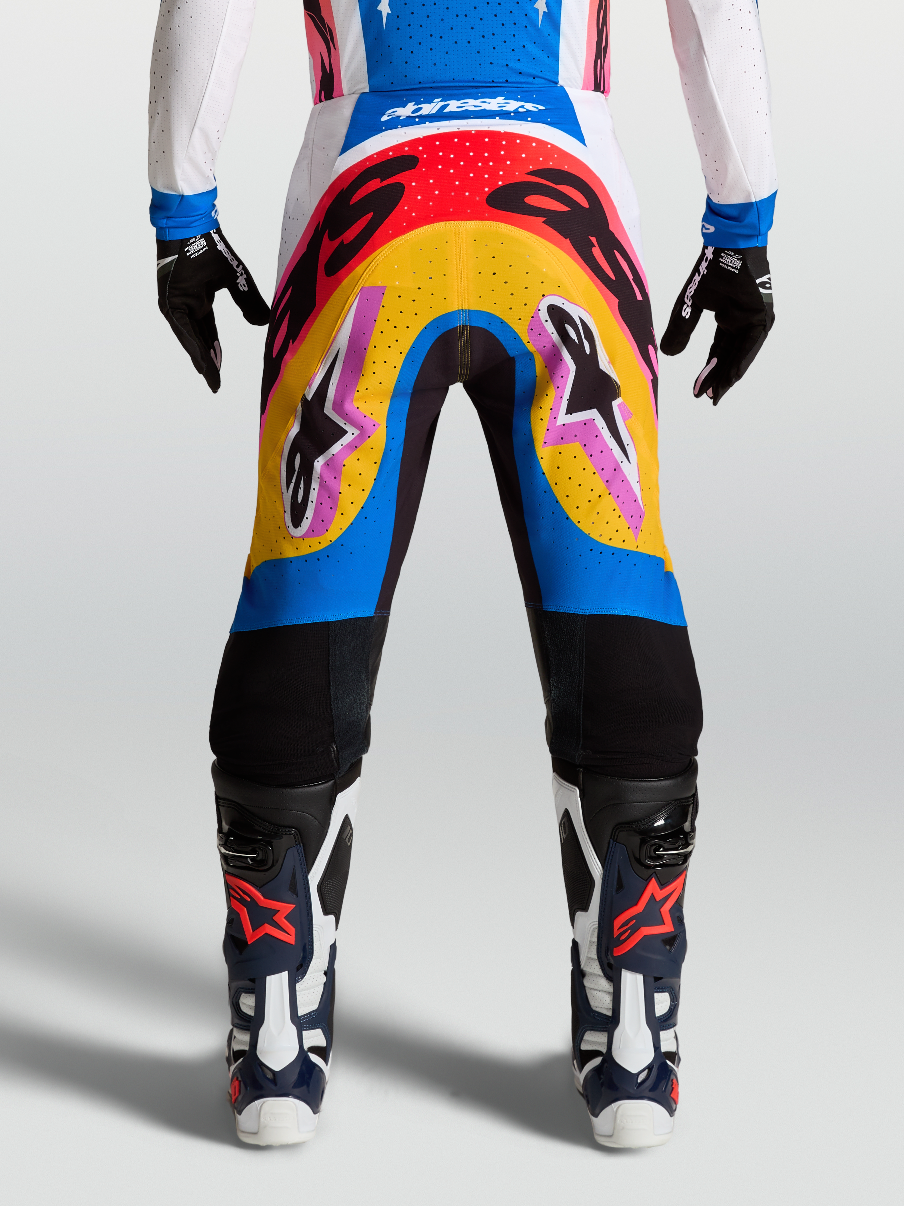 Alpinestars Supertech Dyna, calças de motocross profissionais, azul e amarelo, design multicolorido para corrida, leves e flexíveis.