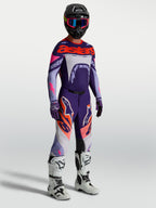 Alpinestars Calças Supertech Dyna, calças de motocross para homem, roxas e rosa fluo, com botas de corrida brancas.