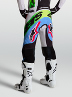 Alpinestars Calças Supertech Dyna, calças de motocross para homem, lilás claro, verde e preto, com áreas perfuradas, vista traseira num modelo
