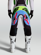 Alpinestars calças Supertech Dyna, calças de motocross para homem, vista traseira lilás e verde fluo com painéis perfurados.