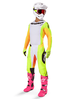 Alpinestars 2025 Techstar Melt Gear Set, complete motocross racing outfit, white jersey with yellow and orange sleeves, neon yellow pants, bright pink boots, white helmet with red goggles, yellow gloves, vibrant colorful racing apparel
