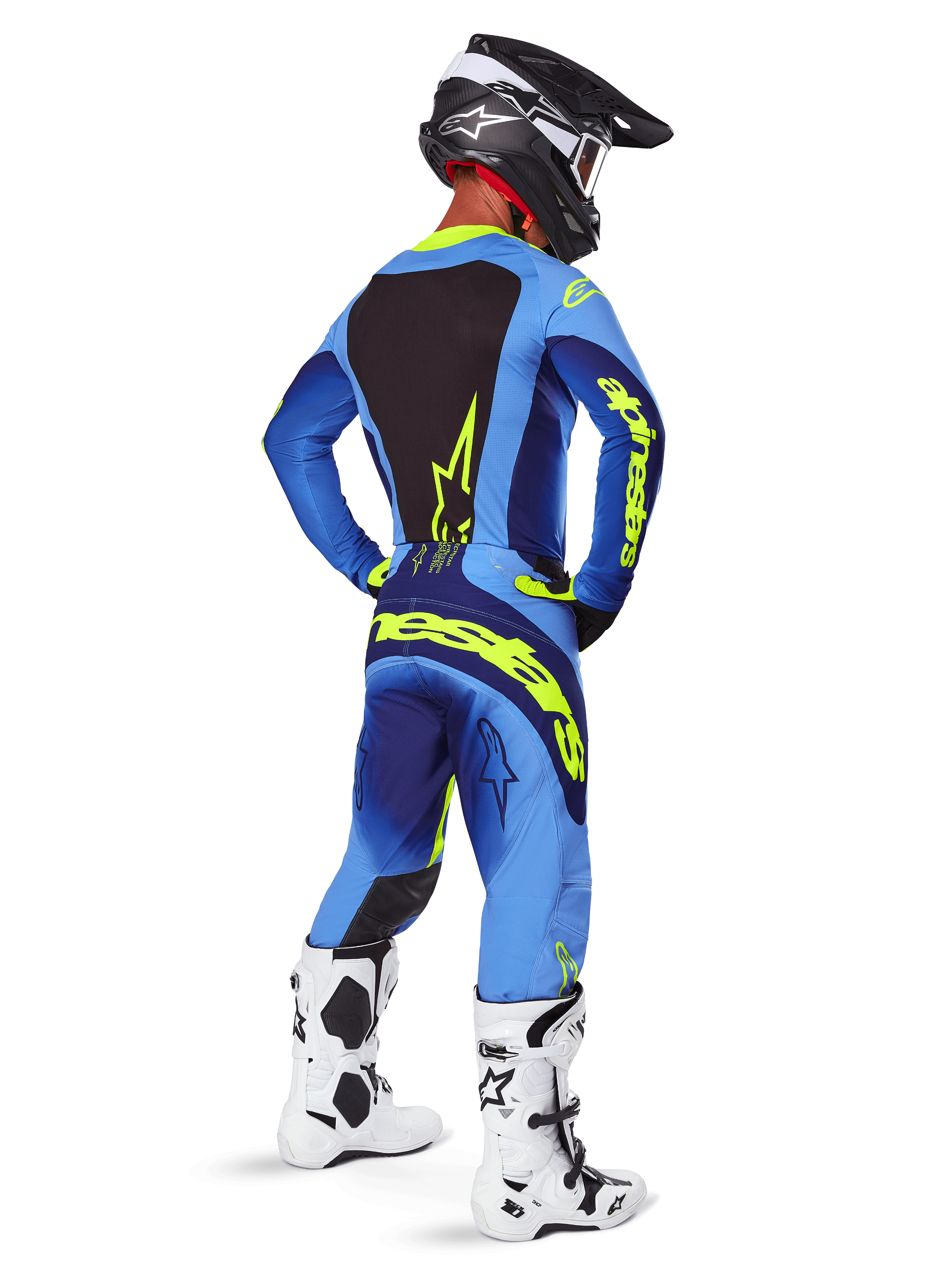 Alpinestars 2025 Techstar Melt Pants, equipamento de motocross, Amarelo Fluo Azul, vista traseira de piloto com camisola azul a condizer e marca amarela grande, botas brancas e pretas e capacete preto, conjunto de corrida coordenado para desempenho off-road
