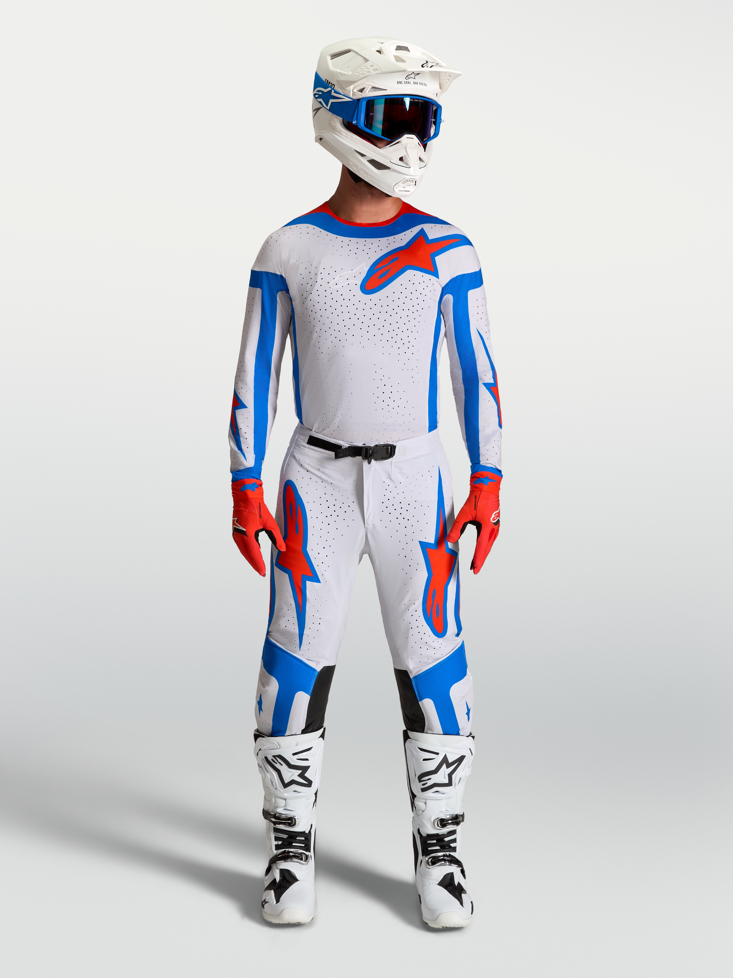 Alpinestars Supertech Vesta, conjunto de motocross lilás claro e vermelho cardeal, com camisola, calças e botas de corrida.