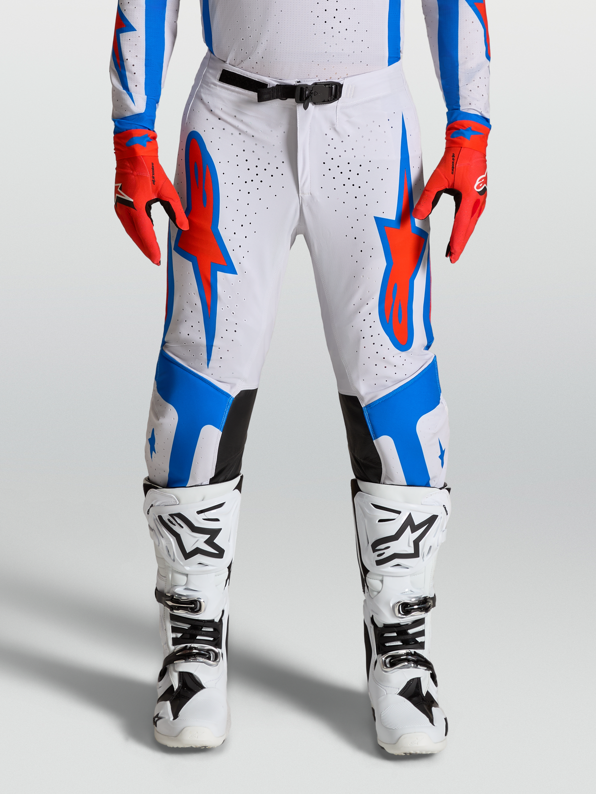 Alpinestars Supertech Vesta, calças de motocross e todo-o-terreno, brancas com detalhes em azul e vermelho.