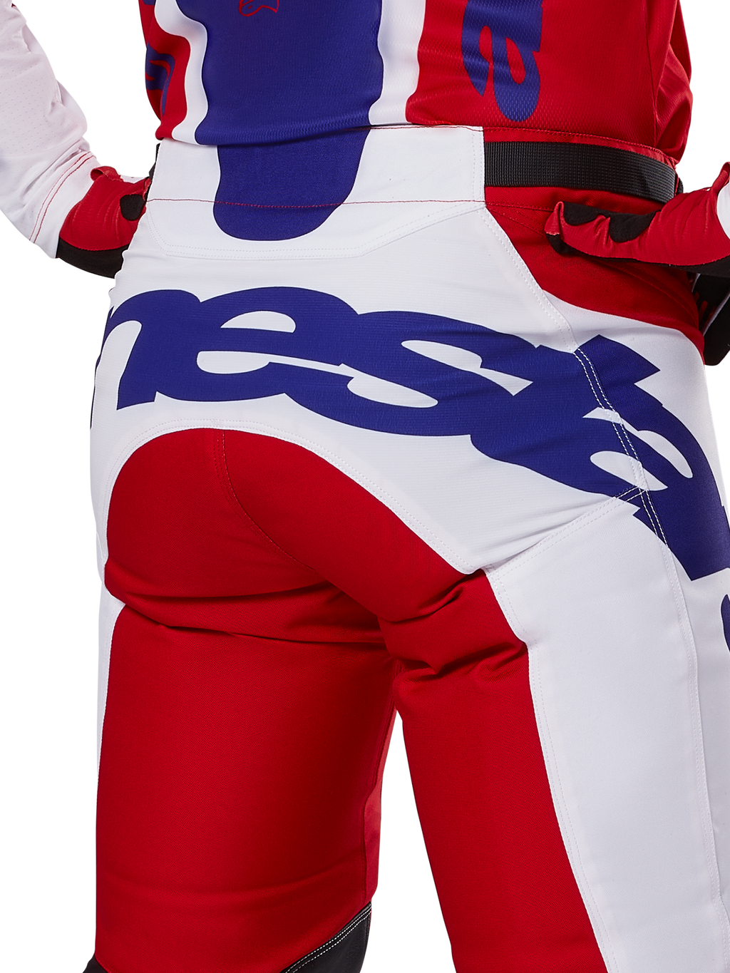 Alpinestars 2025 Racer Veil Pants, calças de motocross, vermelho vivo e branco com logótipos em azul, detalhe da vista traseira na zona do assento com um logótipo Alpinestars grande, usadas como parte de um conjunto coordenado de corrida off-road