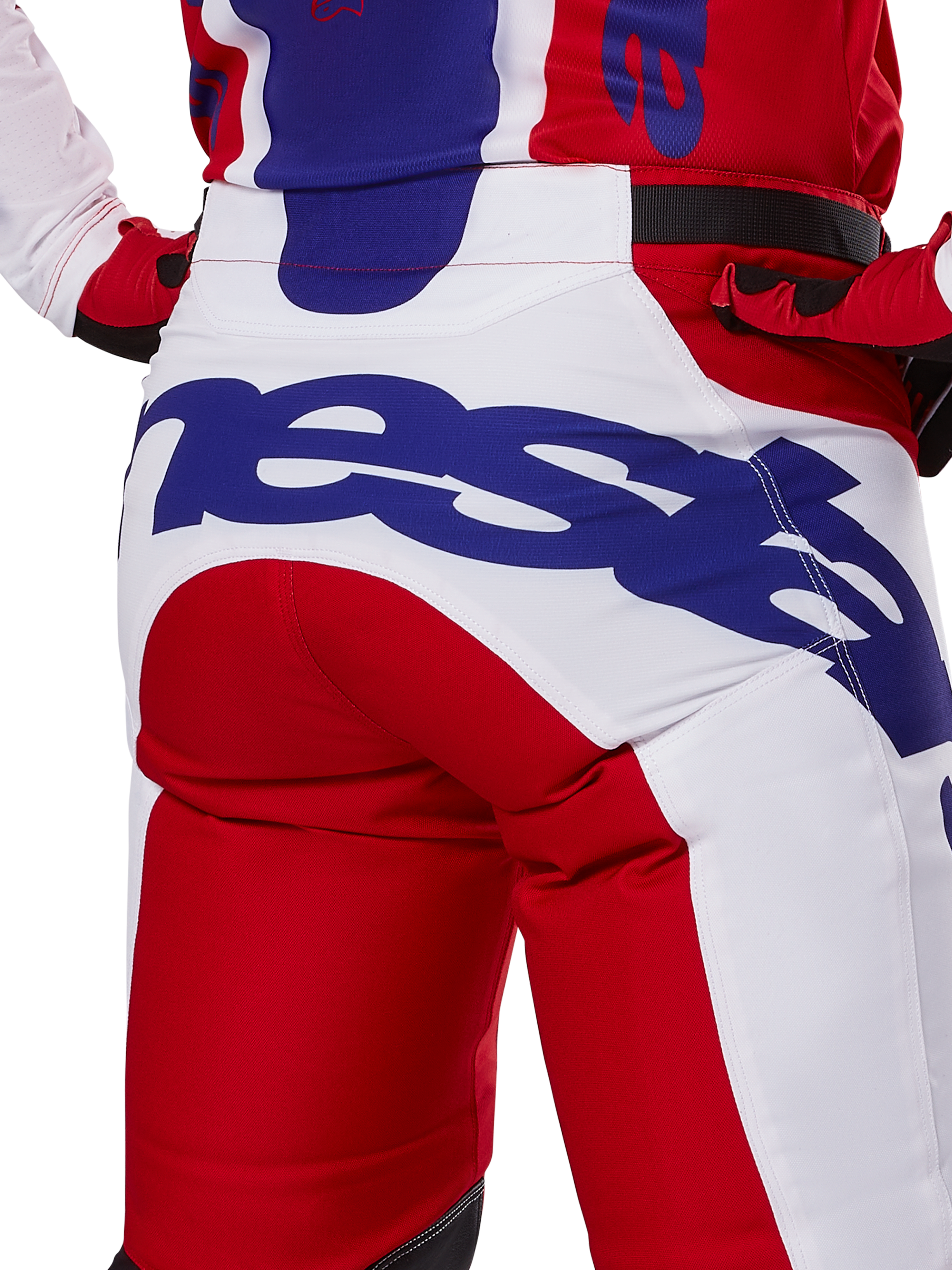 Alpinestars 2025 Racer Veil Pants, calças de motocross, vermelho vivo e branco com logótipos em azul, detalhe da vista traseira na zona do assento com um logótipo Alpinestars grande, usadas como parte de um conjunto coordenado de corrida off-road