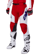 Alpinestars 2025 Racer Veil Pants, calças de motocross, vermelho vivo e branco, com logótipos Alpinestars em azul e painéis internos dos joelhos em pele preta, usadas com luvas vermelhas a condizer e botas de motocross brancas, conjunto de equipamento coordenado para corridas off-road
