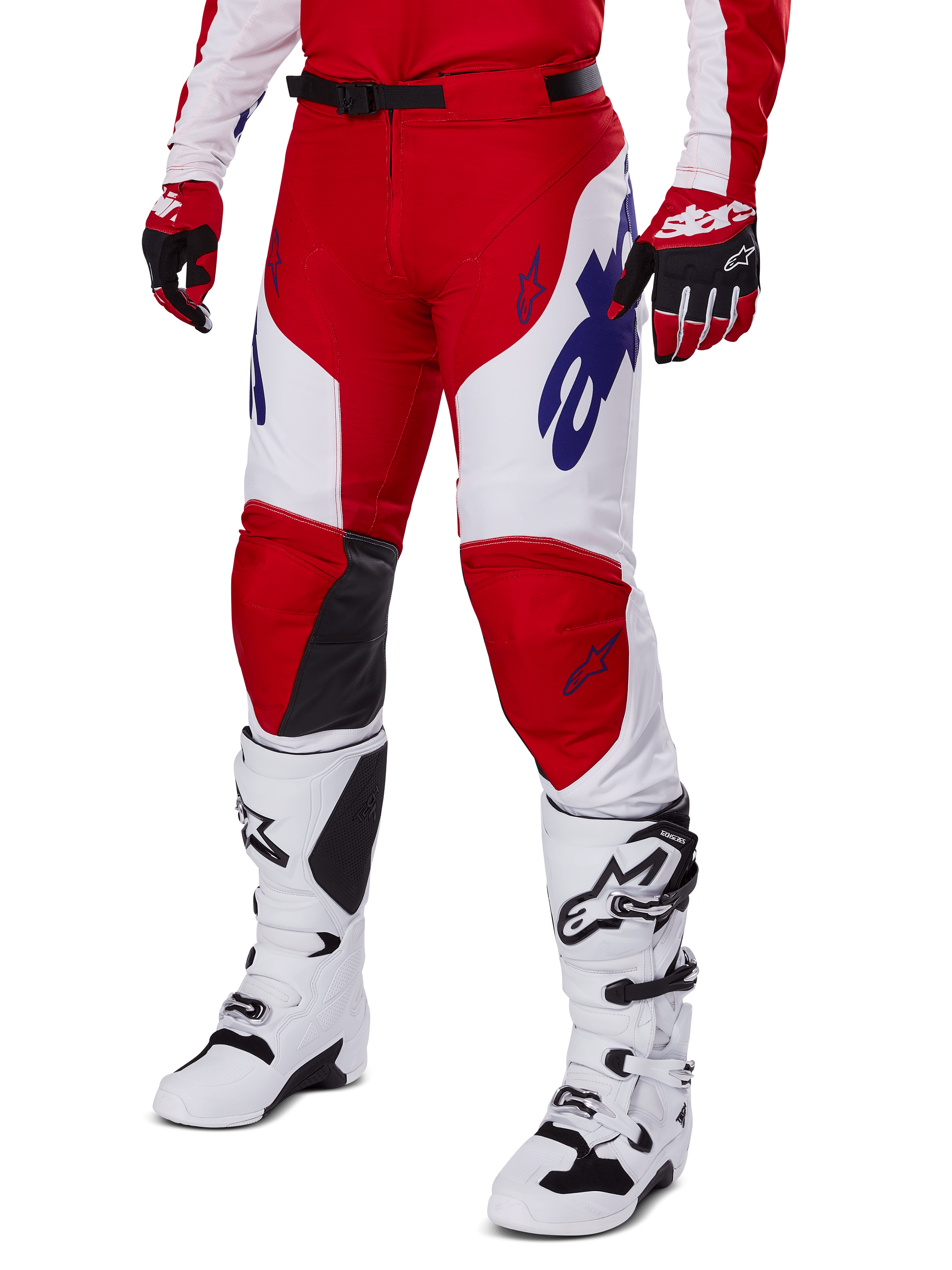 Alpinestars 2025 Racer Veil Pants, calças de motocross, vermelho vivo e branco, com logótipos Alpinestars em azul e painéis internos dos joelhos em pele preta, usadas com luvas vermelhas a condizer e botas de motocross brancas, conjunto de equipamento coordenado para corridas off-road