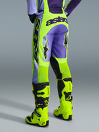 Alpinestars 2026 Racer Portl Pants, calças de motocross, roxo e amarelo néon, vista traseira com a marca astars em destaque e detalhes em roxo, usadas com botas de motocross em amarelo néon a condizer, material sintético durável para corridas fora de estrada