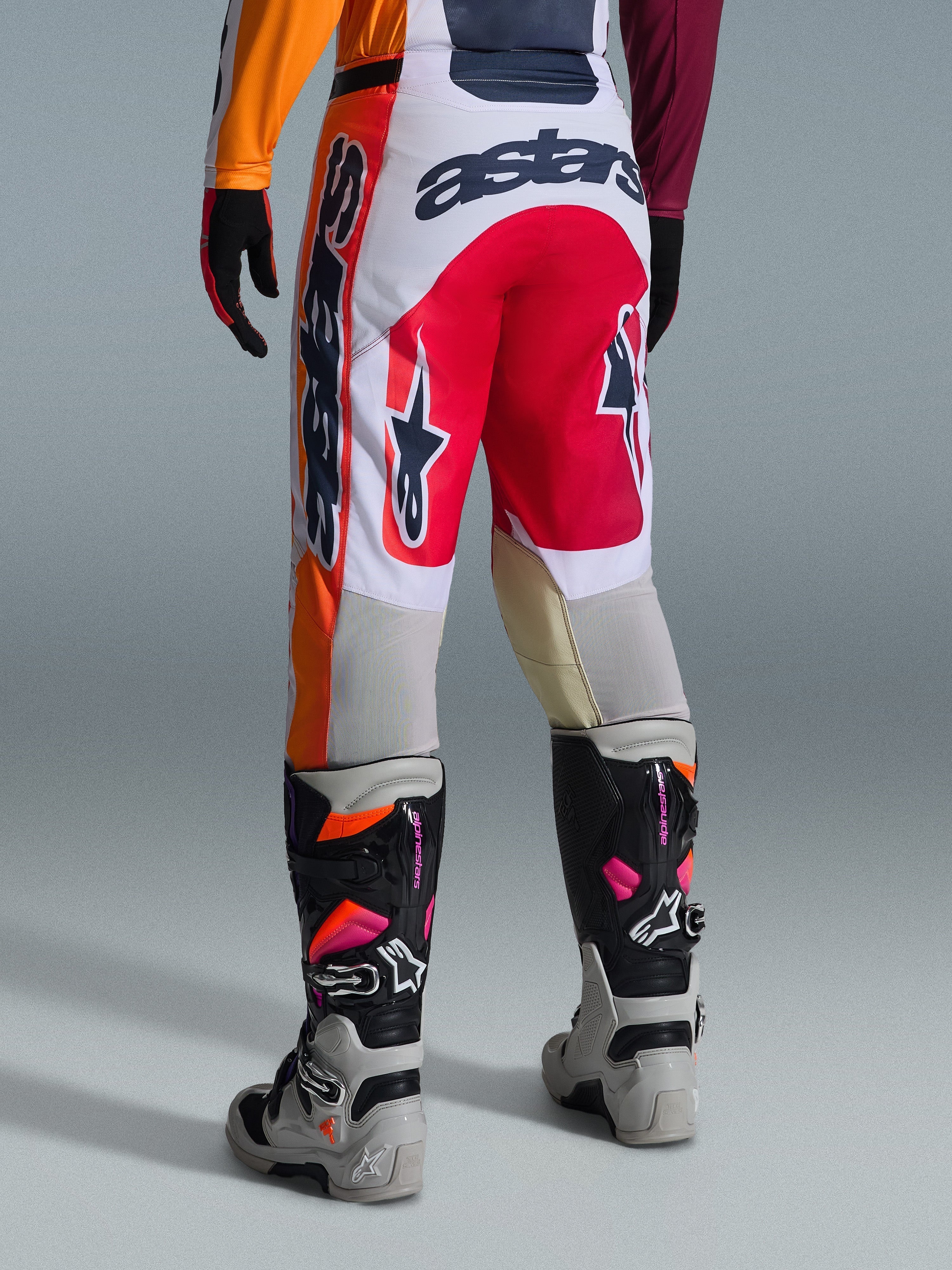 Calças Alpinestars 2026 Racer Portl, calças de motocross, vermelhas, cinzento claro e cinzento escuro, vista traseira com detalhes de marca e logótipo arrojados, combinadas com botas e luvas de motocross coordenadas, equipamento de performance para corridas off-road