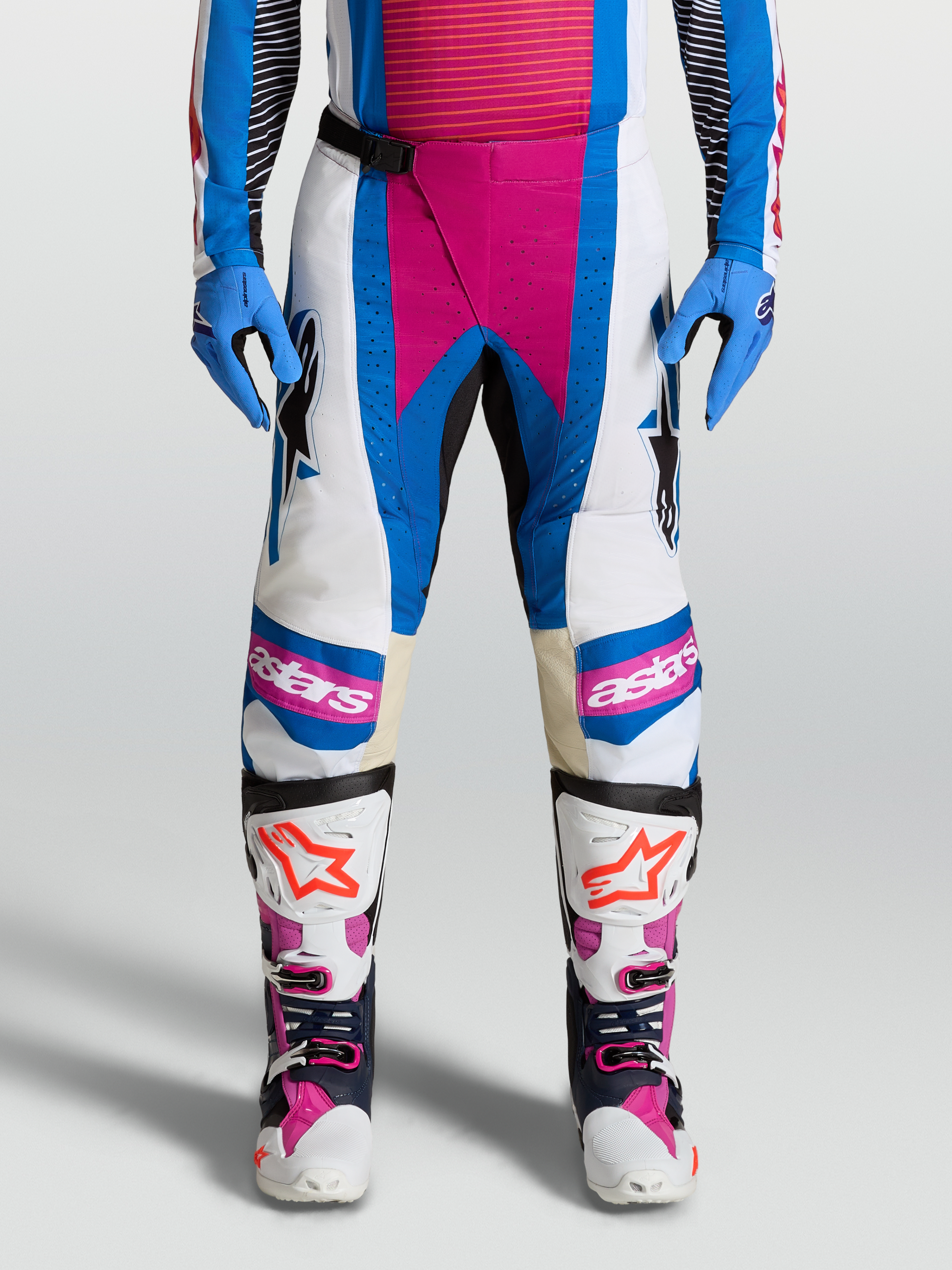 Calças Alpinestars Techstar Maven, calças de motocross off-road, brancas e azuis com detalhes coral vivo e painéis de pele nos joelhos.