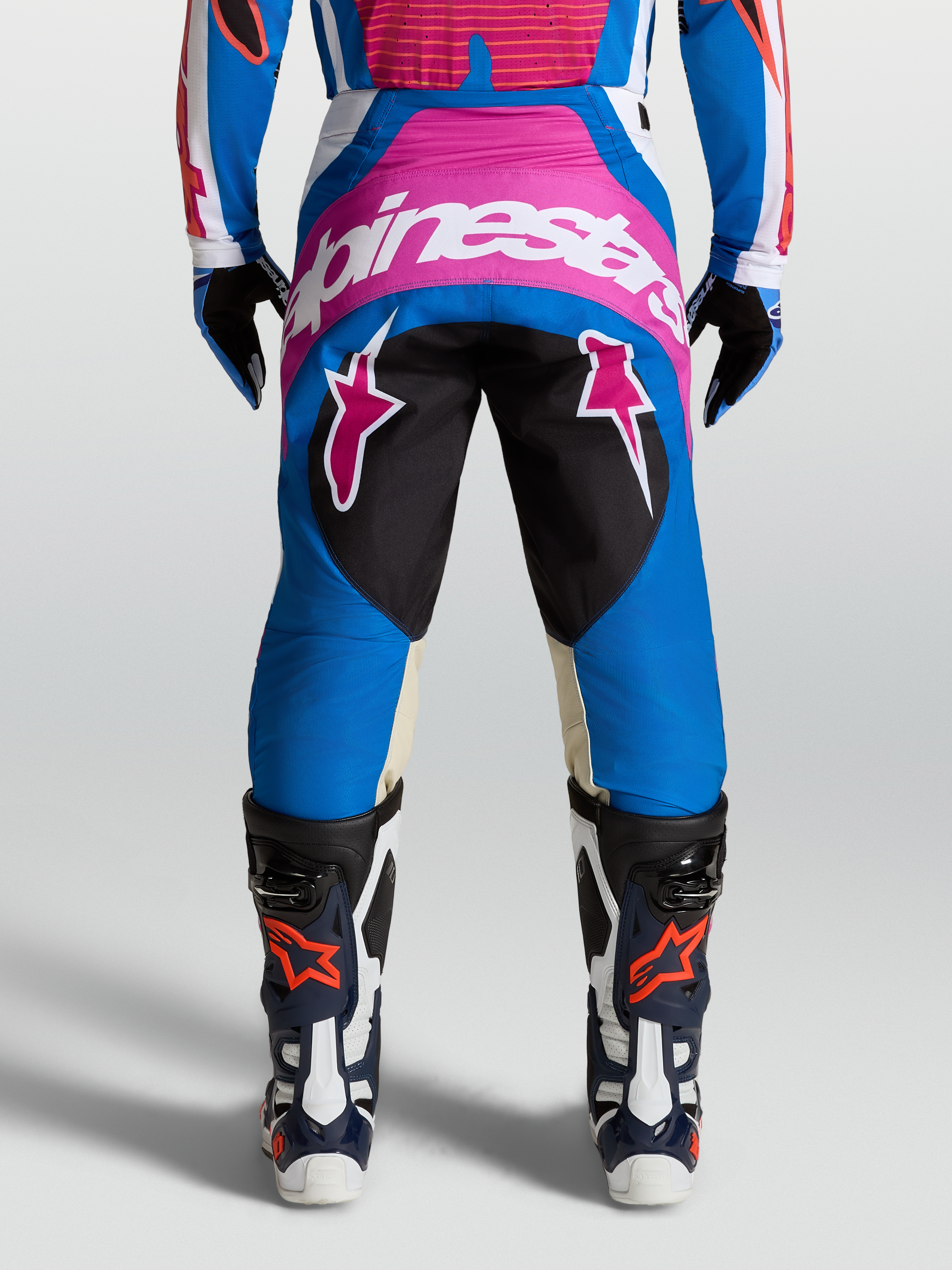 Alpinestars Calças Techstar Maven, calças de motocross azuis e rosa, vista traseira, logótipo branco, painéis em couro de cabra no joelho.