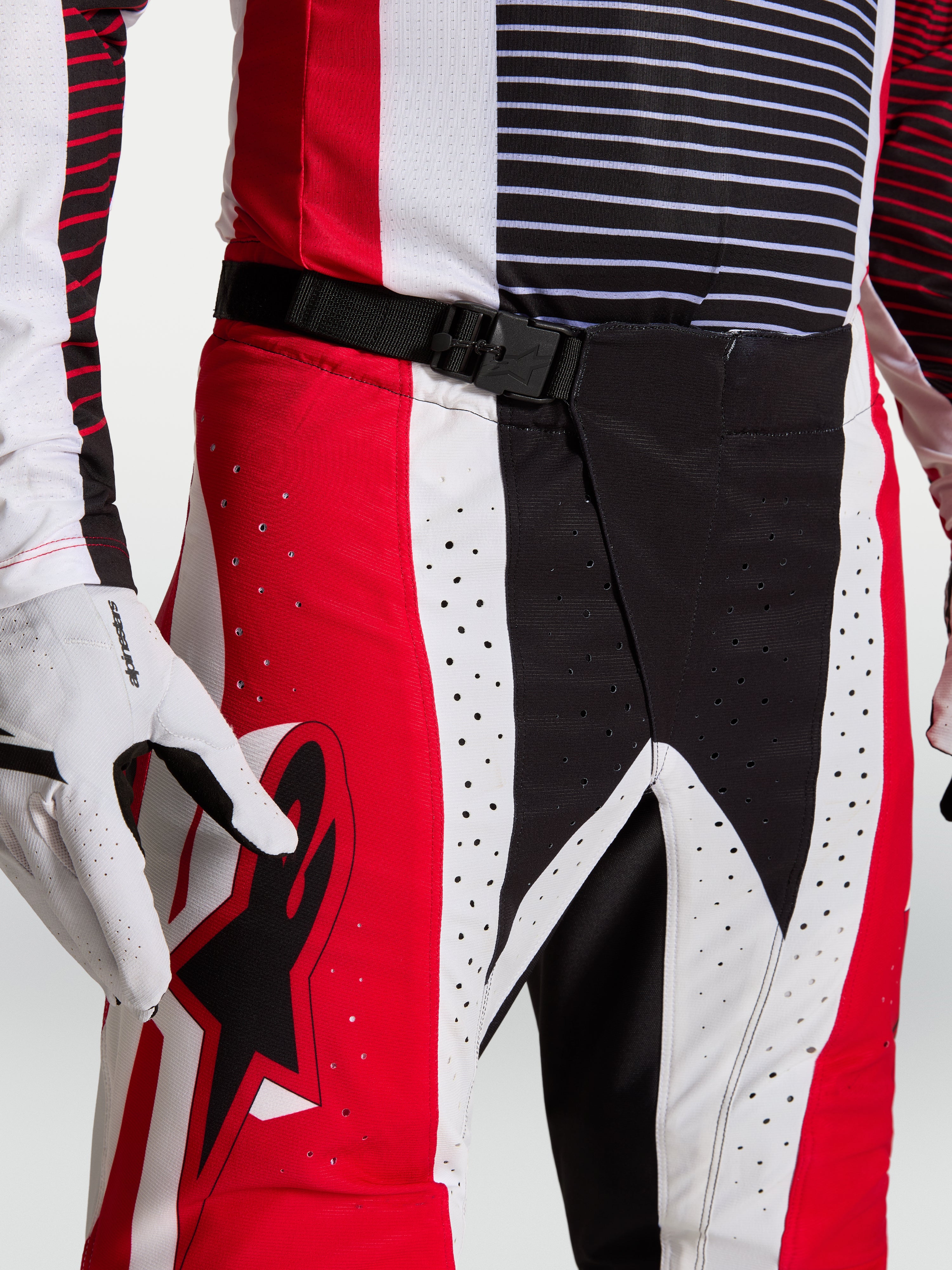 Alpinestars Techstar Maven, calças de motocross vermelhas e pretas, fecho magnético SX2, perfurações a laser, no modelo.