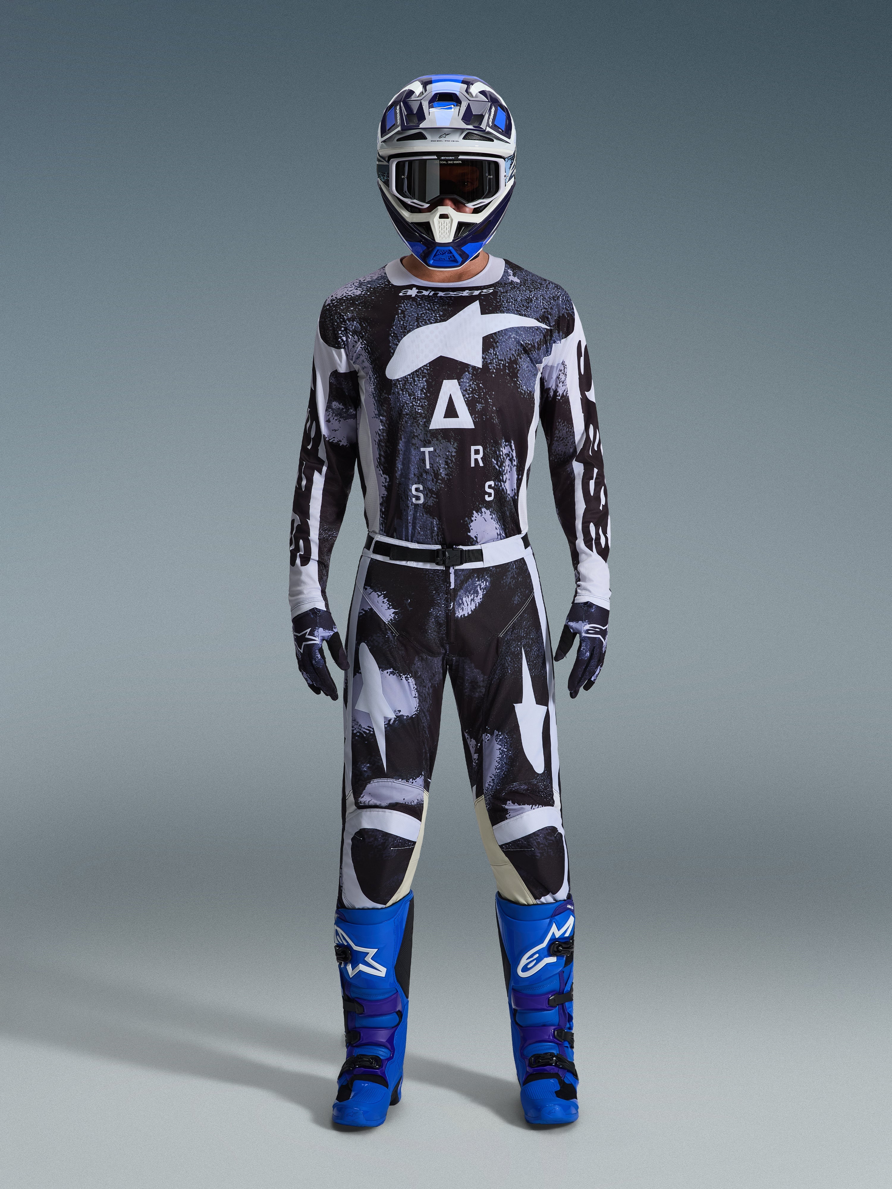 Conjunto de Equipamento Alpinestars Racer Lahnd 2026, fato de motocross, preto e branco com padrão abstrato Iron Camo, combinado com capacete azul e branco e botas azuis brilhantes, kit completo de corrida para performance em todo-o-terreno